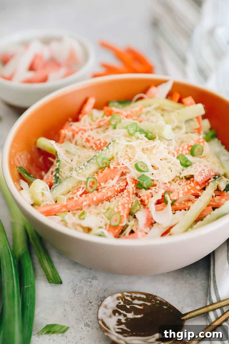 Creamy Spicy Crab Crunch 6 The finished Kani Salad, glistening with creamy dressing and garnished with sesame seeds, ready to be enjoyed in a bowl.