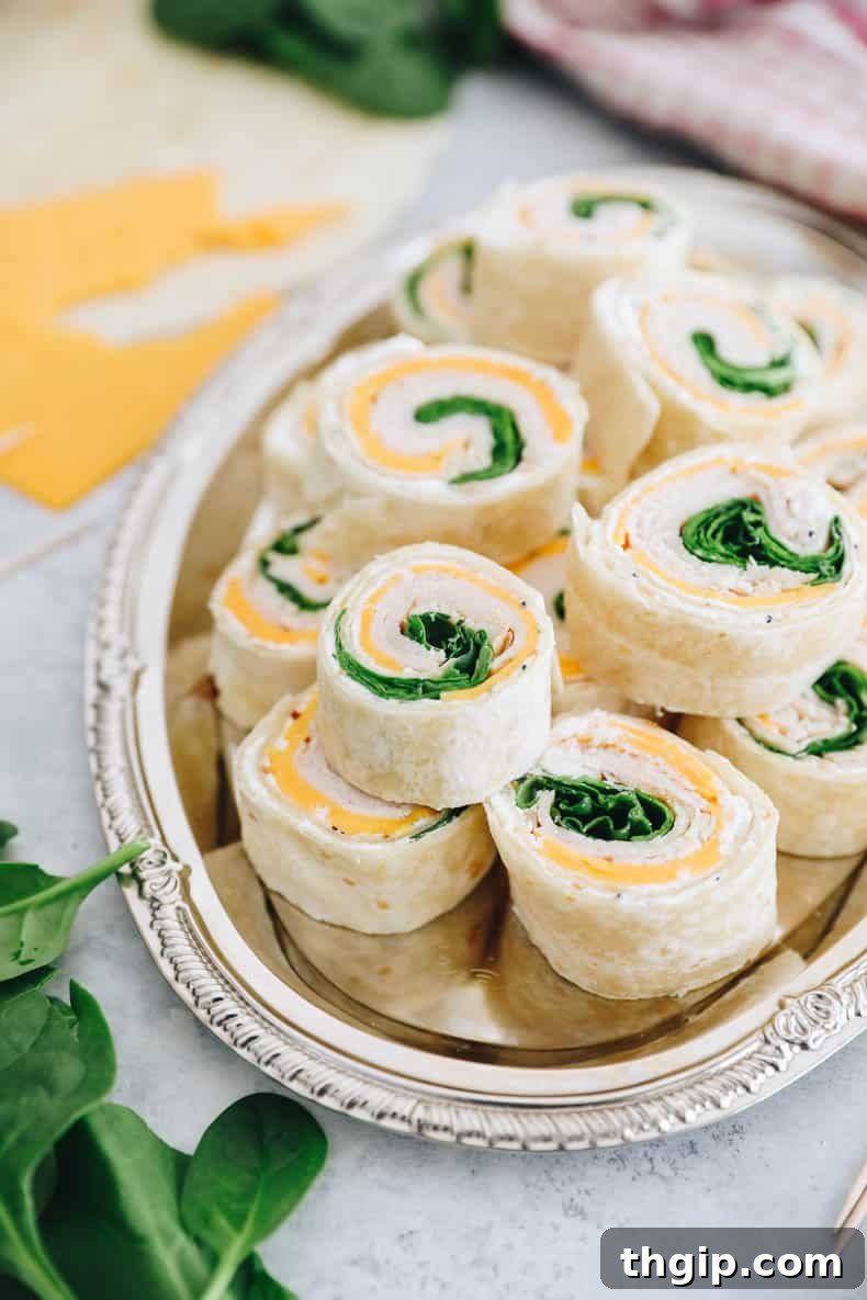 Swirl Bites 2 pinwheel sandwiches with turkey, cheese and spinach on a silver platter