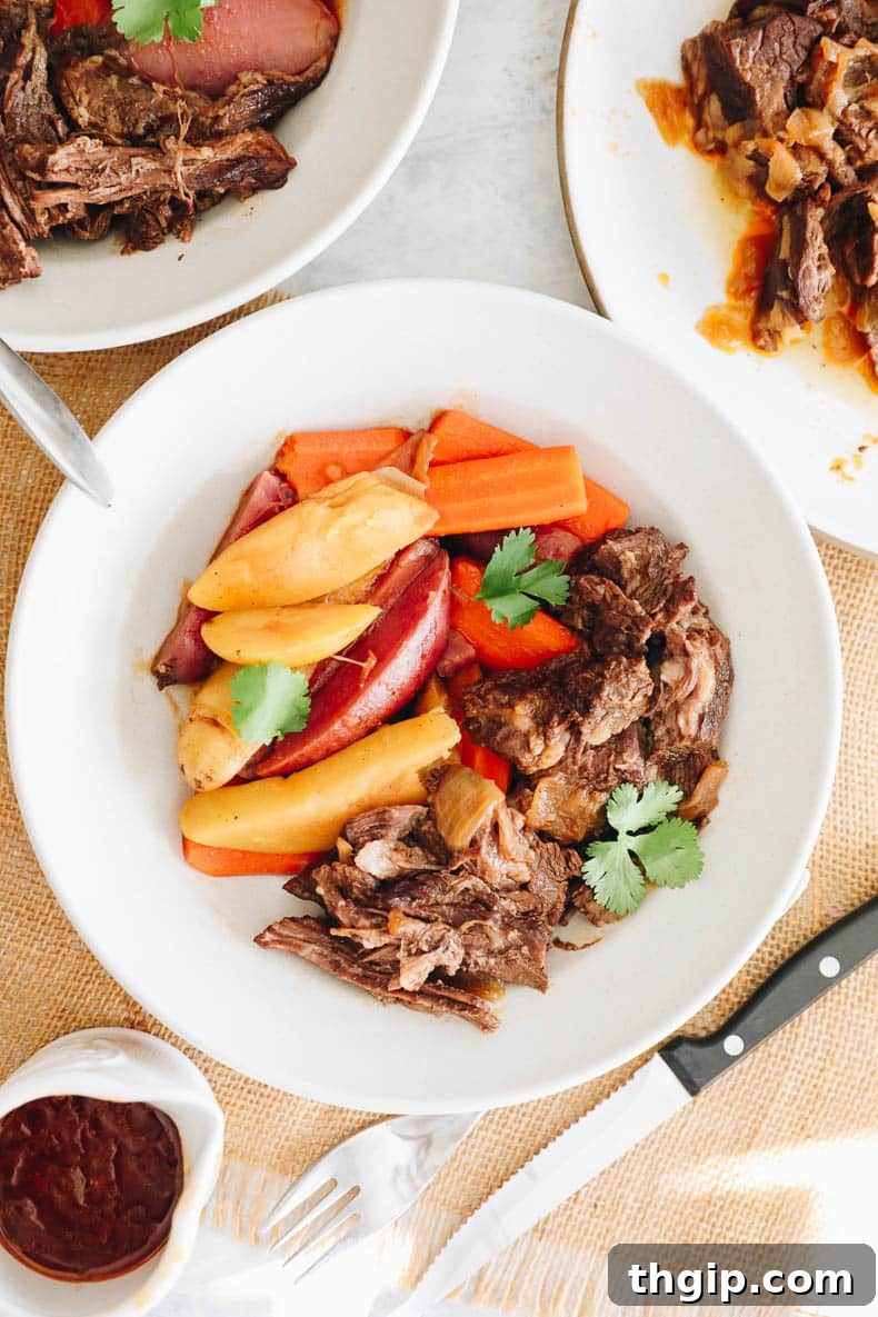 Instant Pot pot roast, potatoes, and carrots beautifully plated in a white shallow bowl.