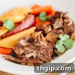 Close up of instant pot pot roast and veggies in a white shallow dish.