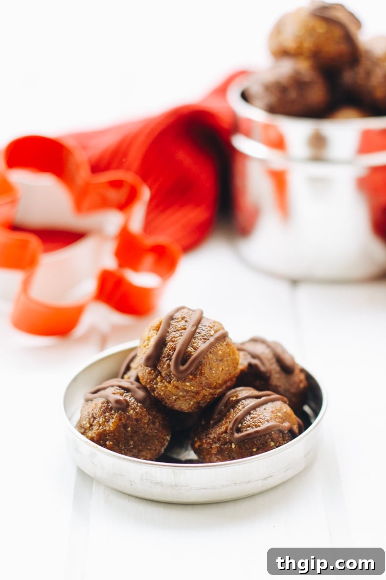 Gingerbread Chocolate Power Bites 2 A batch of freshly made chocolate chip gingerbread energy balls, perfectly round and sprinkled with mini chocolate chips, set against a cozy holiday backdrop.
