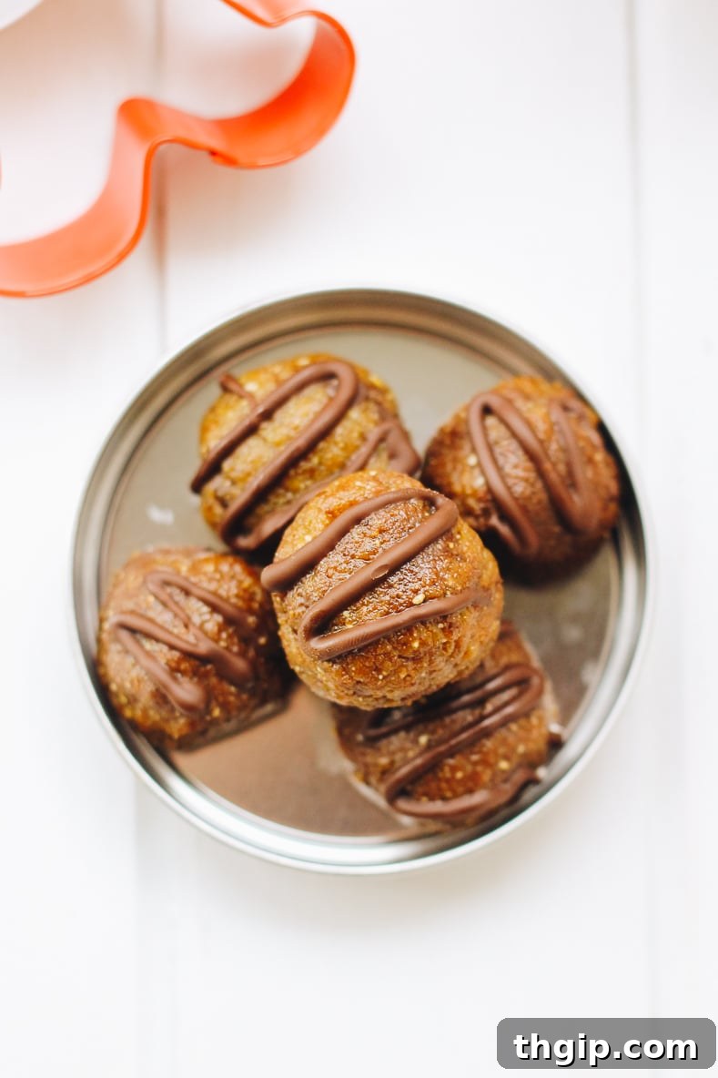 Gingerbread Chocolate Power Bites 3 Three perfectly formed chocolate chip gingerbread energy balls stacked on a small plate, showcasing their inviting texture and festive appeal.