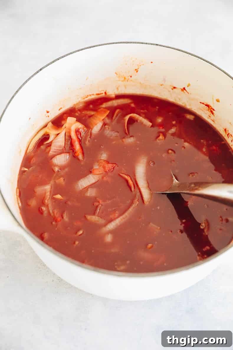 Perfectly Tender Smoked Brisket 7 The savory gravy for the brisket, a rich blend of tomatoes, beef stock, and red wine, simmering in a Dutch oven.
