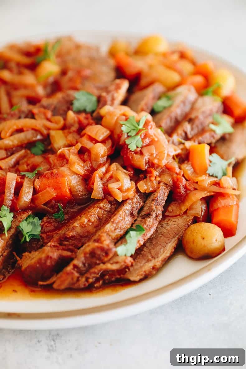 Perfectly Tender Smoked Brisket 9 Oven-roasted brisket, beautifully sliced and served with tender caramelized onions, roasted potatoes, and sweet carrots, glistening in its rich sauce.