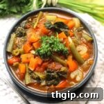 Overhead image of a healthy vegetable soup in a blue bowl, garnished minimally.
