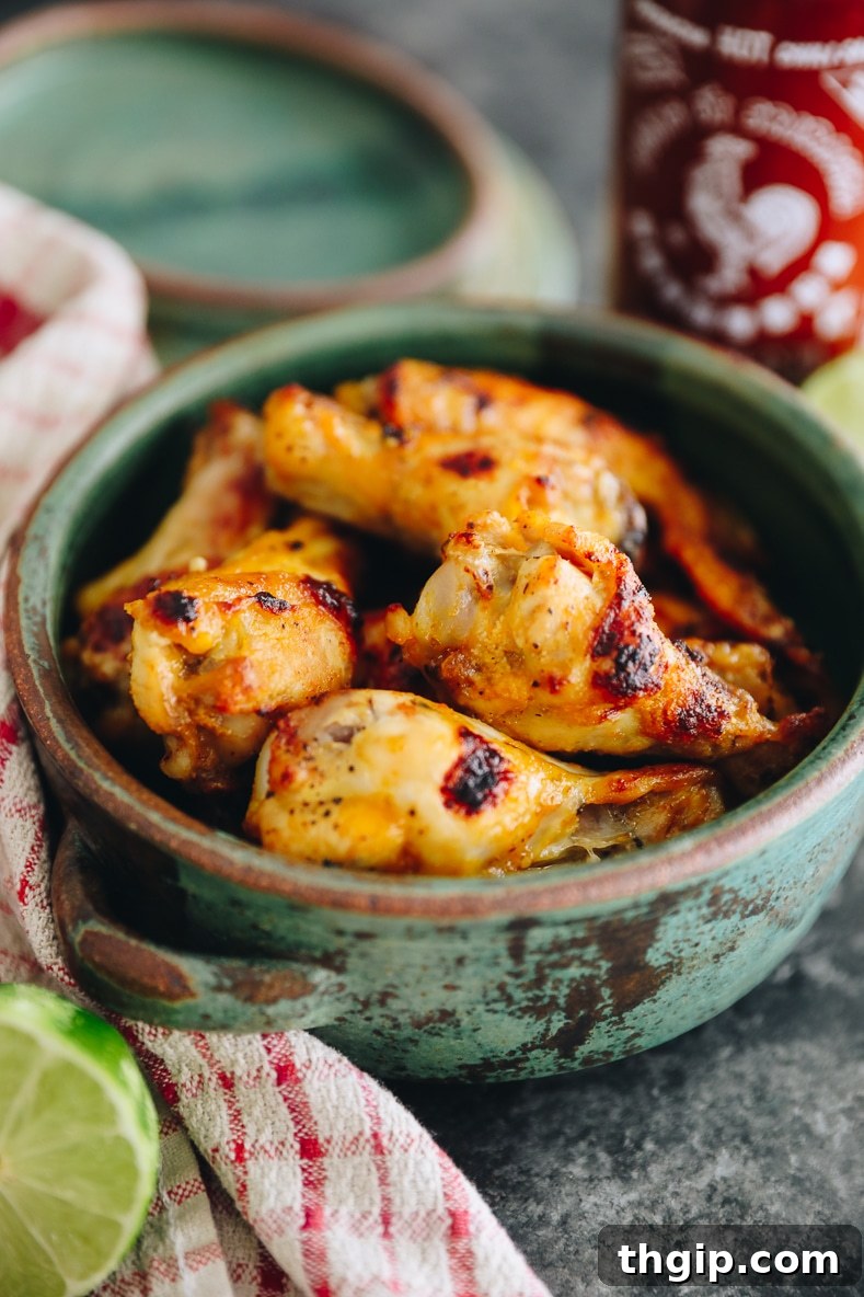 Fırında Sriracha Limonlu Tavuk Kanatları 2 Baked Sriracha Lime Chicken Wings in a bowl with lime wedges and cilantro