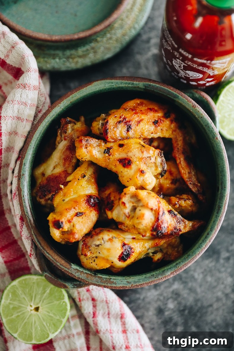 Fırında Sriracha Limonlu Tavuk Kanatları 8 A final close-up of Sriracha Lime Chicken Wings garnished with lime wedges and cilantro
