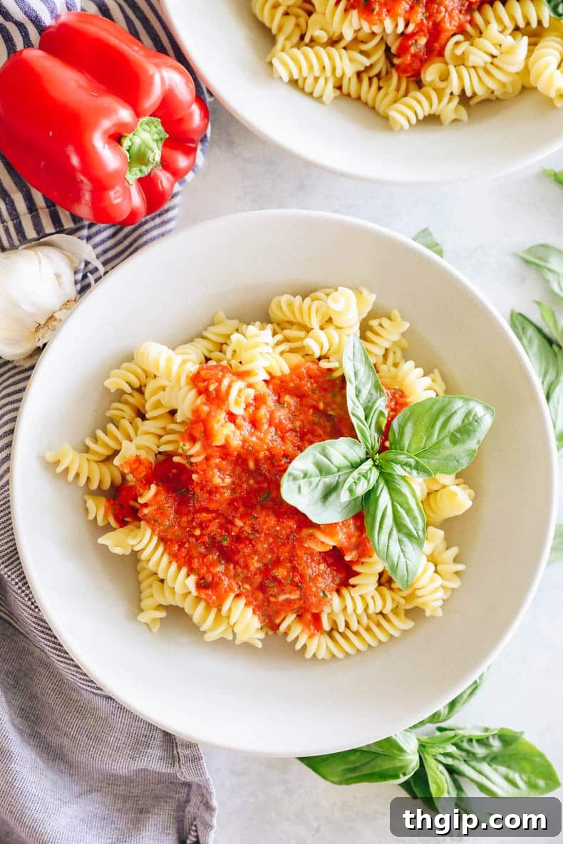 Flame-Kissed Red Pepper Spread 3 roasted red pepper pasta in a white shallow bowl with basil.