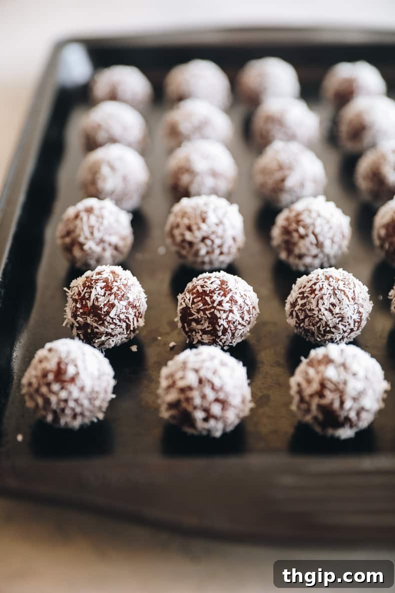 Coconut Almond Bliss Bites 6 Almond joy energy balls lined on a baking sheet.