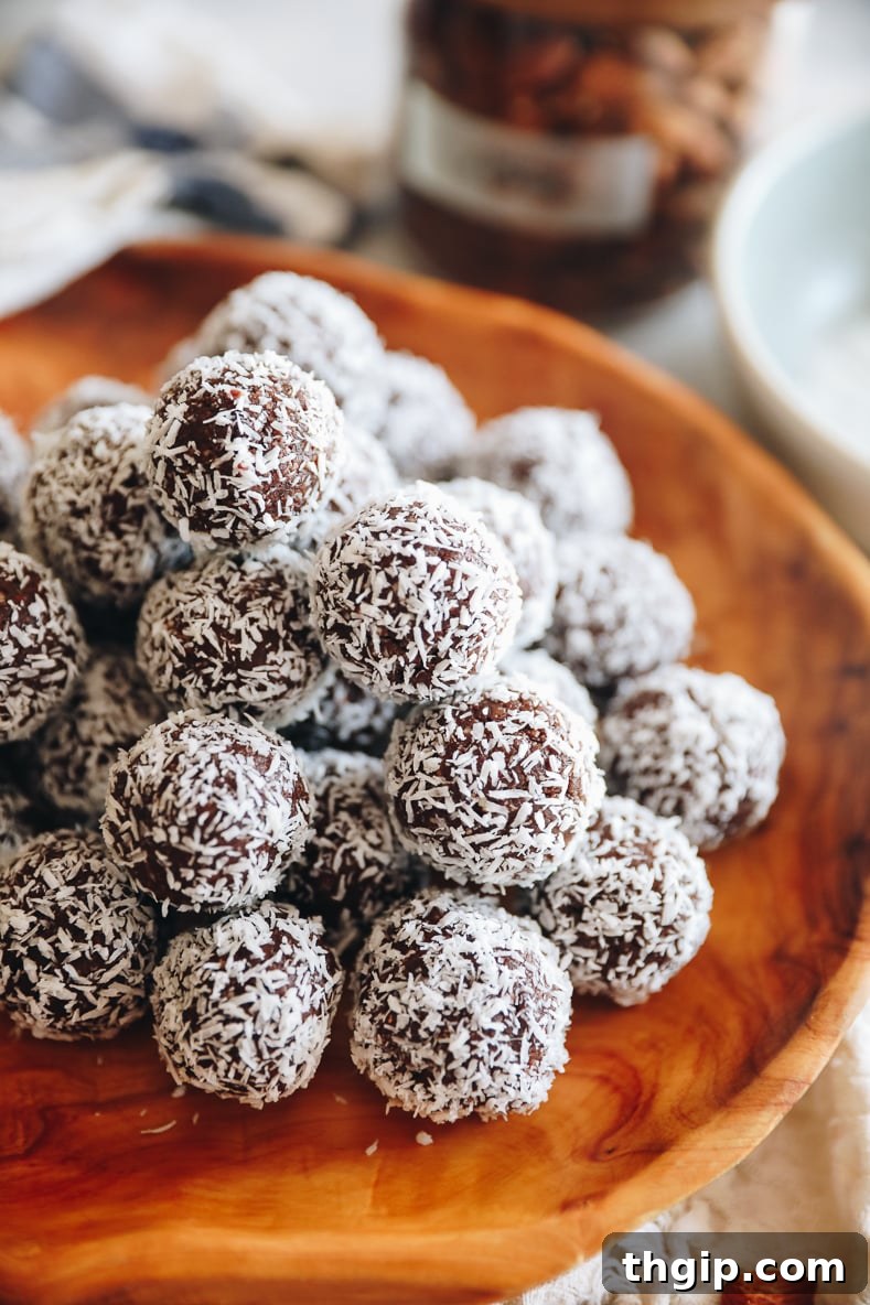 Coconut Almond Bliss Bites 8 Angled shot of almond joy energy balls stacked on a wooden platter.