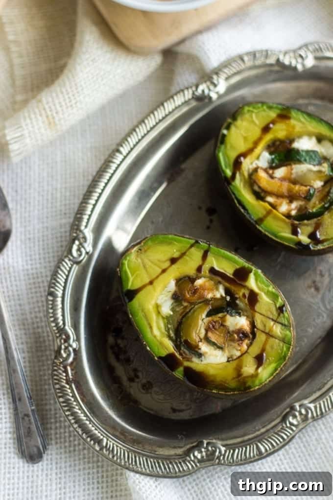 Baked Goat Cheese Stuffed Avocados, garnished with herbs