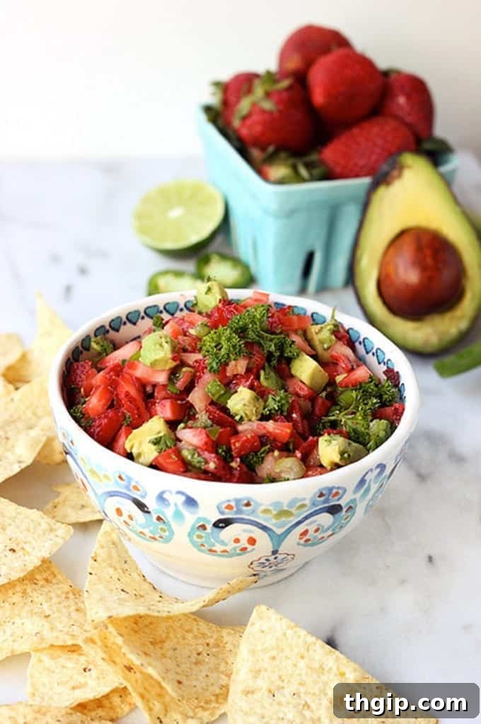 Strawberry Avocado Jalapeno Salsa in a white bowl with lime wedges