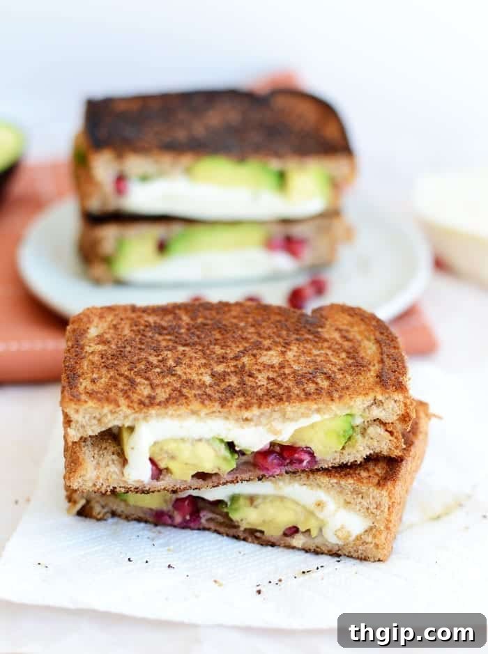 Avocado Pomegranate Grilled Cheese, golden brown and cut in half