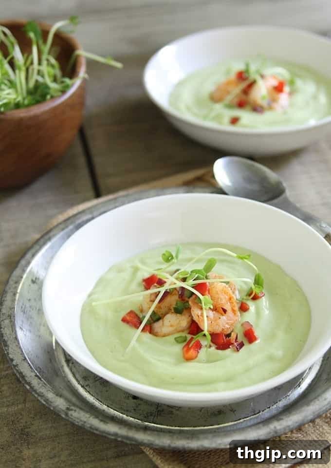 Chilled Avocado Sweet Corn Soup with lime shrimp salsa, served in a glass bowl