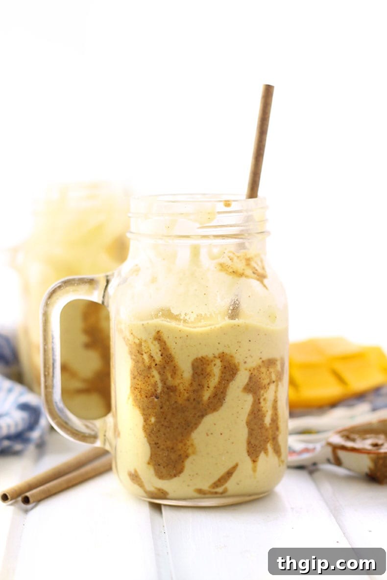 Tropical Mango Almond Bliss 2 Creamy Mango Almond Butter Smoothie in a glass, ready to be enjoyed.
