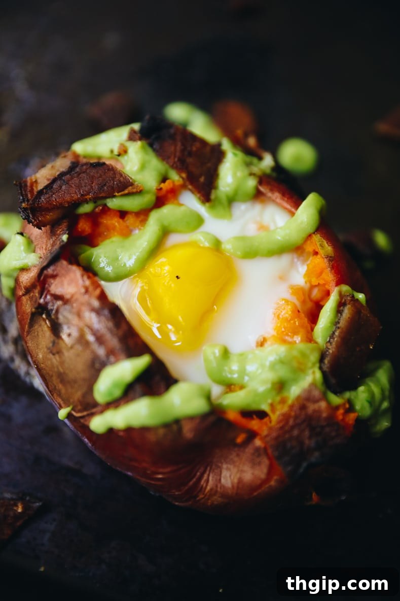 Hearty Sweet Potato Egg Boats with Creamy Avocado and Crispy Bacon 2 Sweet Potato Egg Boats with Avocado Crema and Crispy Bacon, a healthy and delicious breakfast or lunch option.