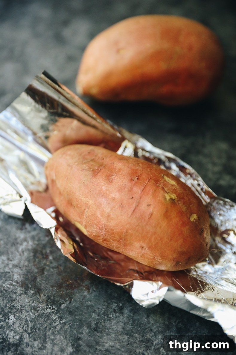 Hearty Sweet Potato Egg Boats with Creamy Avocado and Crispy Bacon 4 Sweet potatoes wrapped in foil, ready for baking in the oven for egg boats.