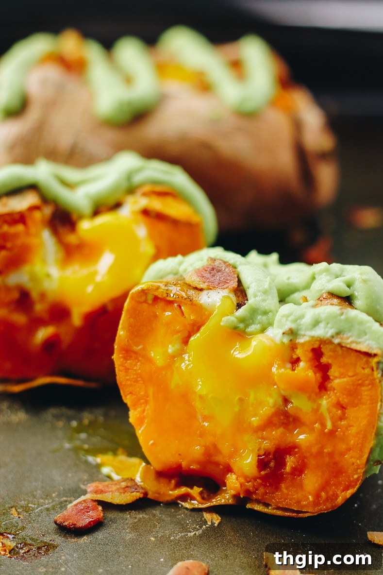 Hearty Sweet Potato Egg Boats with Creamy Avocado and Crispy Bacon 7 Assembled Sweet Potato Egg Boat, topped with avocado crema and crispy bacon bits, ready to serve.