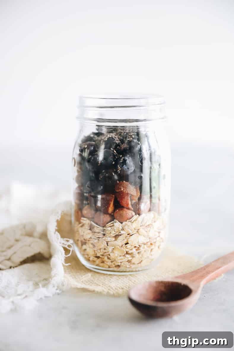 The third step in making Bircher Muesli: a mason jar with all ingredients combined and stirred, ready for refrigeration.