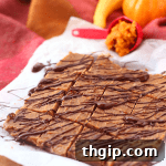A square piece of pumpkin spice freezer fudge topped with a chocolate drizzle.