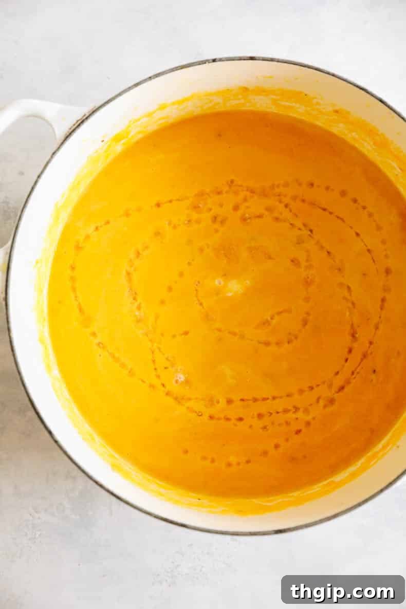 Velvety Ginger Carrot Sunshine 6 Beautifully blended ginger carrot soup, now smooth and creamy, in a white Dutch oven, ready to be served.