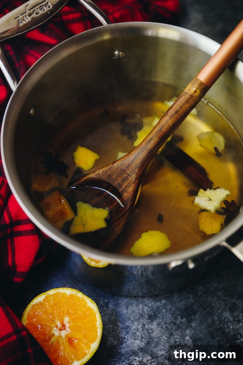 The Scent of Fall: Easy Simmer Pot Spices 2 A pot of fall simmering spices on a stovetop with orange slices, cinnamon sticks, and vanilla beans creating a cozy atmosphere
