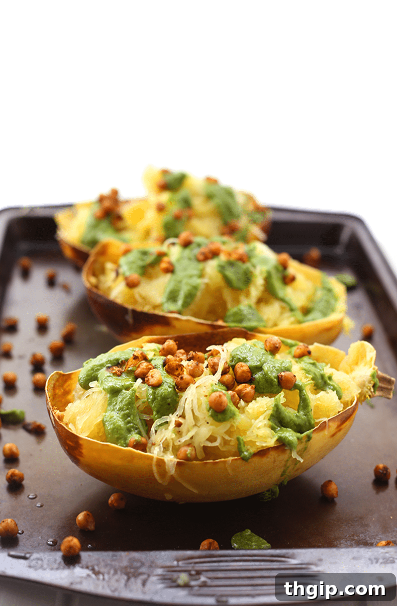 Zesty Pesto Spaghetti Squash with Fiery Crispy Chickpeas 2 A vibrant bowl of Pesto Spaghetti Squash topped with crispy, spiced roasted chickpeas, garnished with fresh basil.