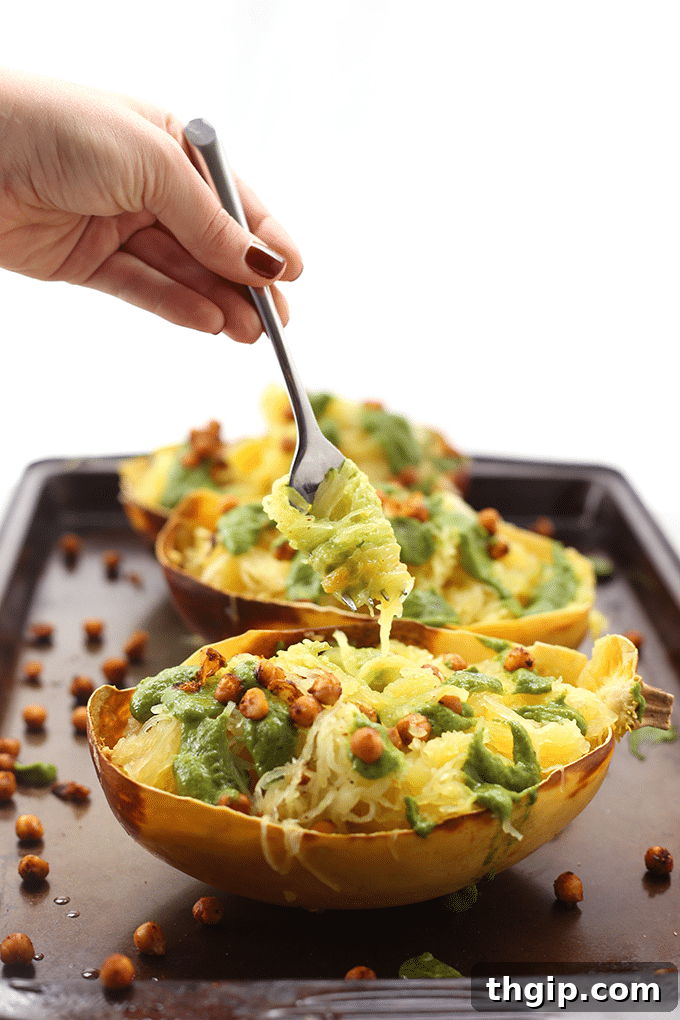 Zesty Pesto Spaghetti Squash with Fiery Crispy Chickpeas 4 A beautifully presented bowl of Pesto Spaghetti Squash with Spicy Roasted Chickpeas, garnished with fresh herbs and a slice of lemon.