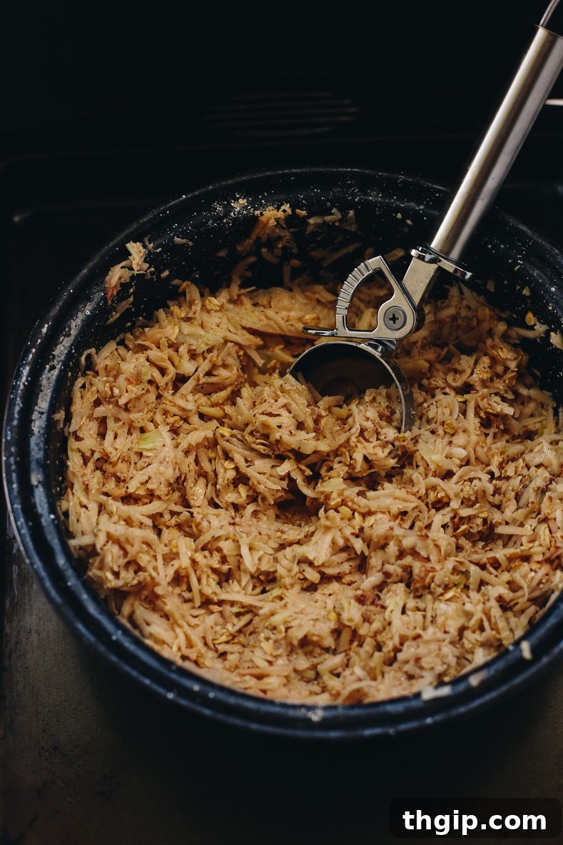 Crispy Baked Latkes Naturally Gluten Free and Vegan 2 Grated potatoes and onions mixed with other ingredients in a bowl for healthy baked latkes.