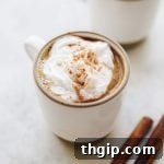 A small mug of superfood hot chocolate with a swirl of cream.