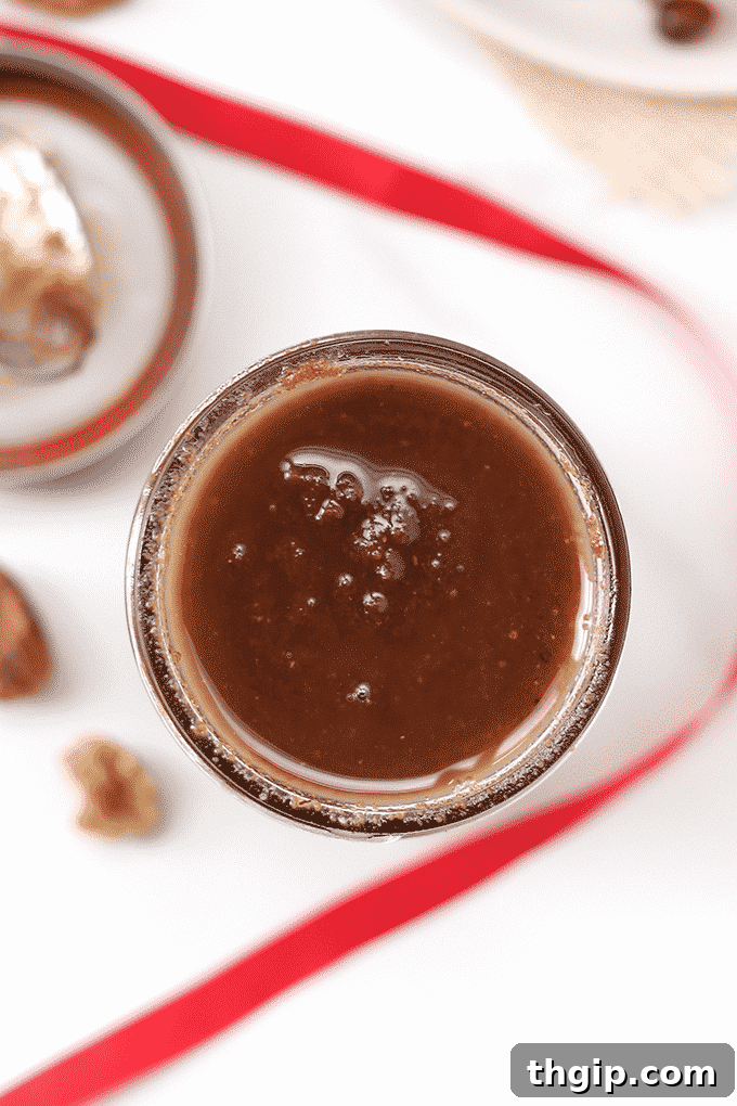 Golden Maple Pecan Spread 4 Maple Pecan Butter in a jar, shown with a spoon and ingredients in the background, emphasizing its homemade appeal.