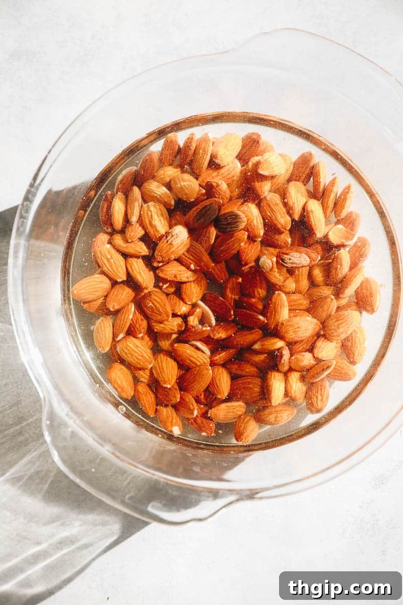 Create Your Own Creamy Almond Milk 3 Soaking raw almonds in a clear glass bowl filled with water overnight.